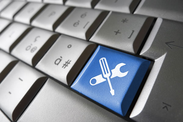 a grey keyboard with one key colored blue and labeled with a screwdriver icon and a wrench icon